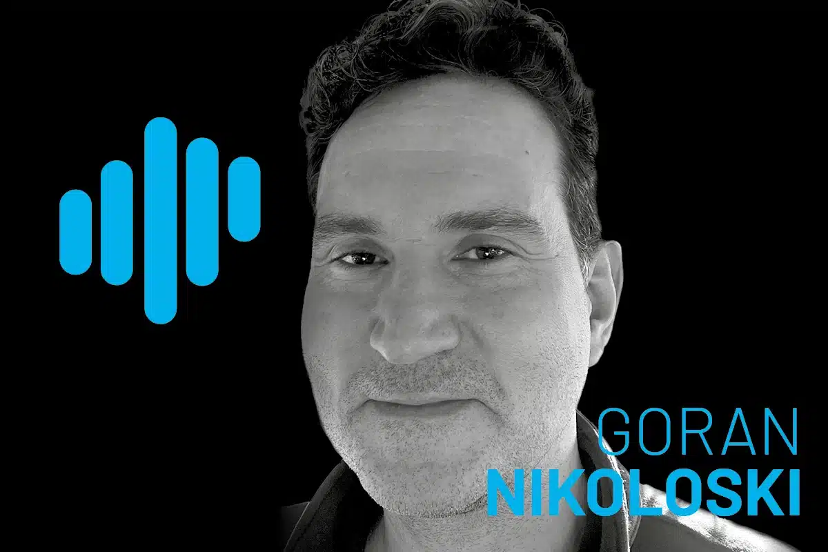 Goran Nikoloski portrait with blue podcast waveform logo on black background, grayscale headshot highlighting modern tech aesthetics for botiss biomaterials.
