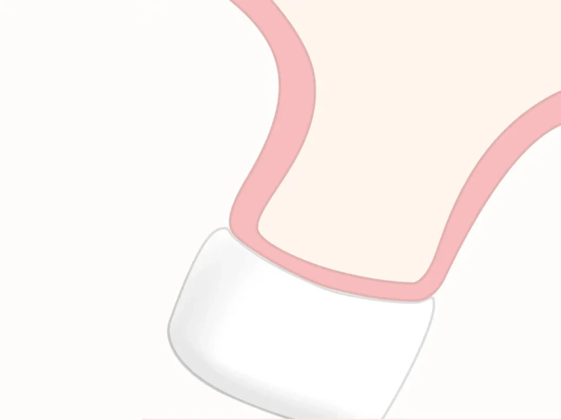 Close-up of a pink and white cosmetic applicator with a rounded tip.