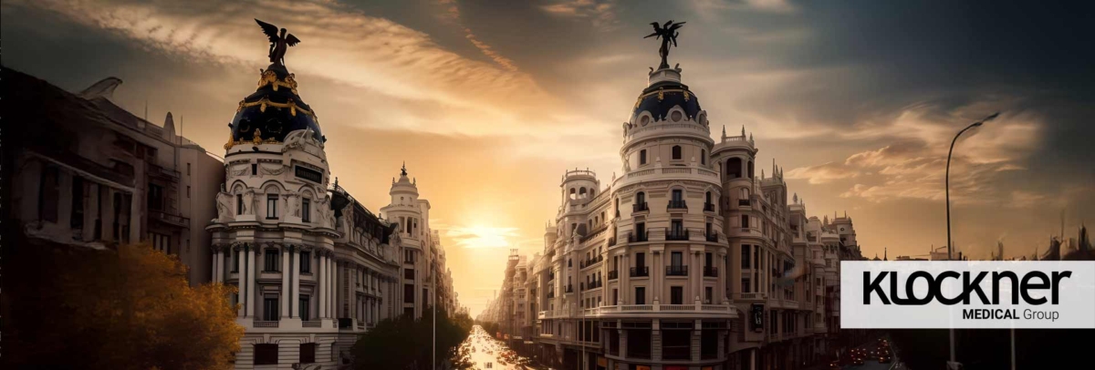 Madrid sunset skyline with ornate neoclassical façades, domed towers, and a warm golden glow; branding from KLOCKNER Medical Group visible on the right on the right.