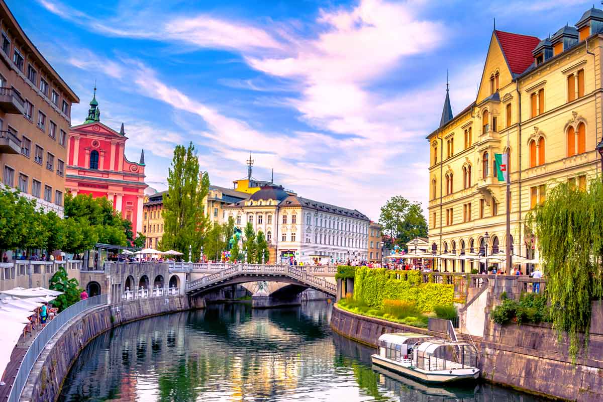 Ljubljana canal with arched bridges and historic facades under vivid sky, mirroring digital planning for horizontal and vertical bone augmentation.