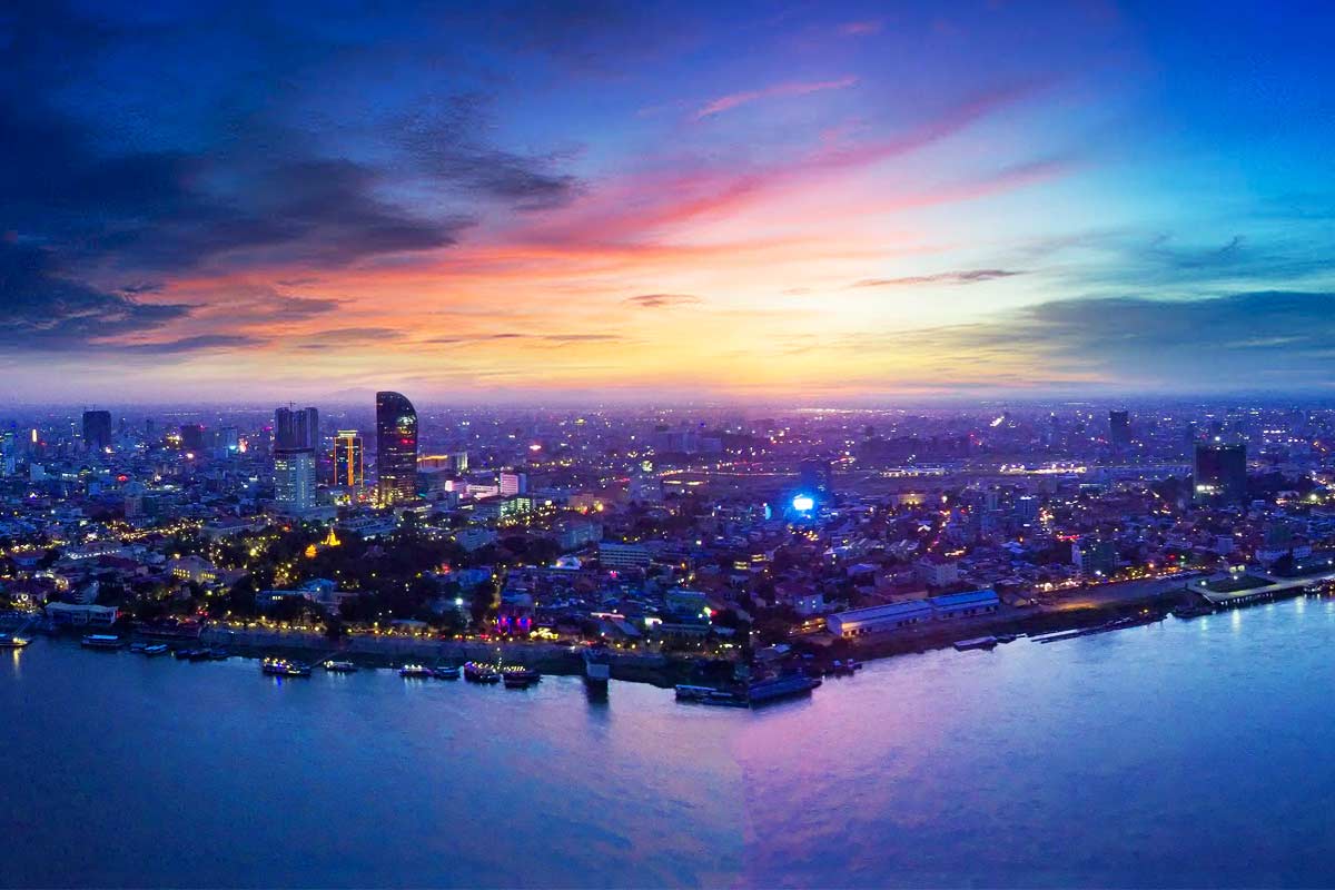 Dusk skyline over Phnom Penh with river lights under a blue-purple sky, with PROMPT-2-SHIELD for AI-led clinical decision-making in ARP.